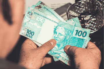 homem segurando dinheiro para representar as principais erros ao contratar um empréstimo
